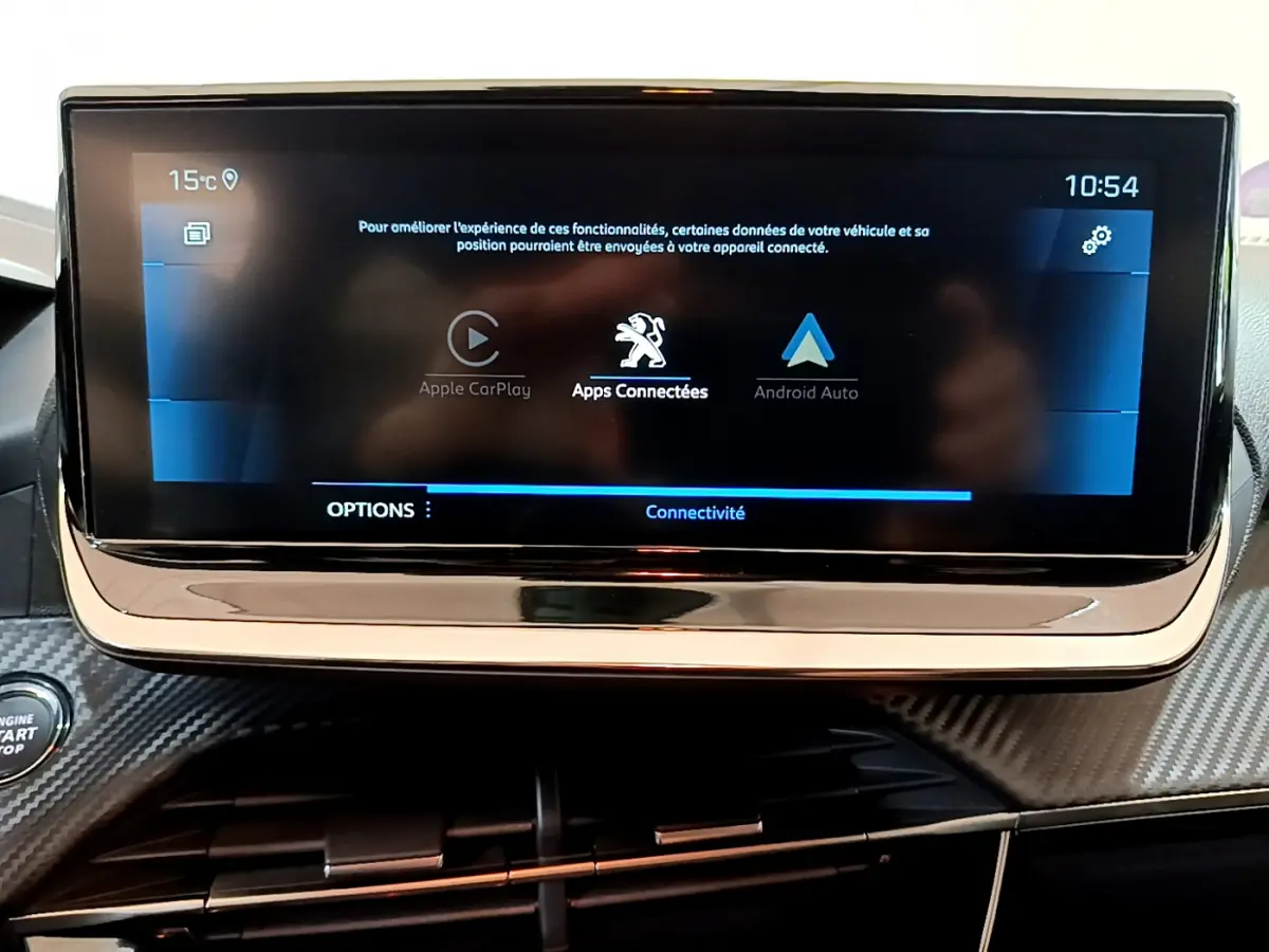 Écran tactile central affichant les options Apple CarPlay et Android Auto dans l’habitacle d’une Peugeot 208 gris foncé.