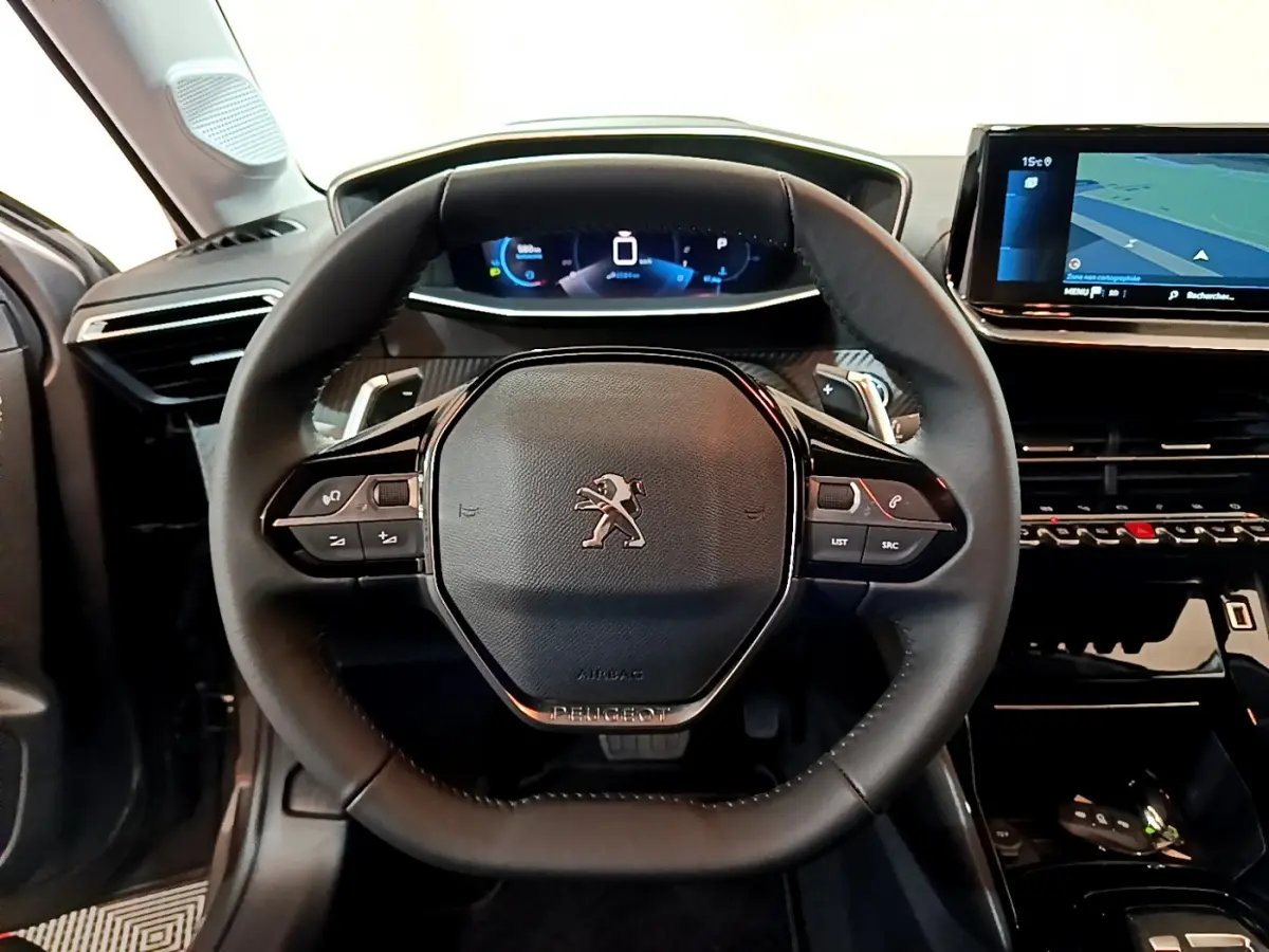 Vue frontale du volant cuir noir et du tableau de bord numérique de la Peugeot 208 gris foncé 2022 Allure Pack.