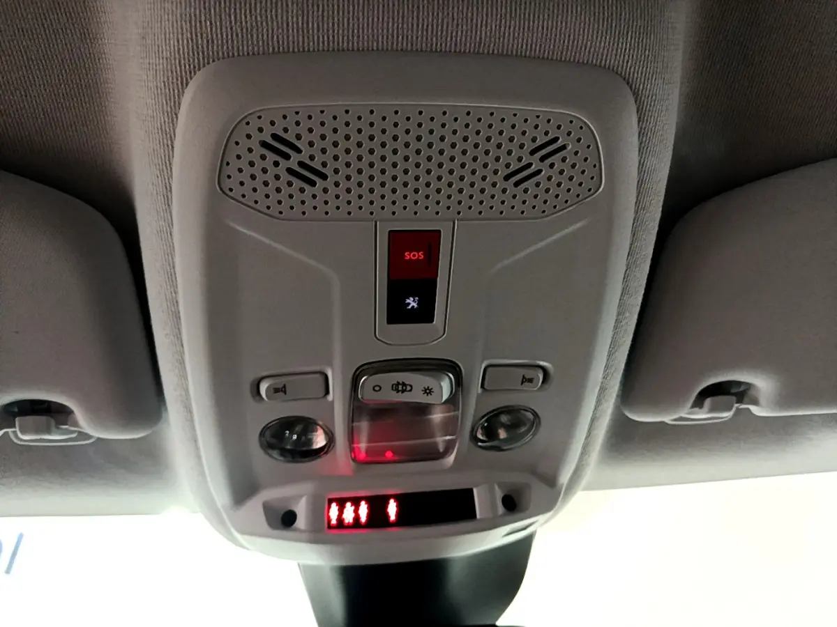 Vue intérieure du plafonnier gris clair avec bouton SOS et éclairage dans une Peugeot 208 gris foncé de 2022.