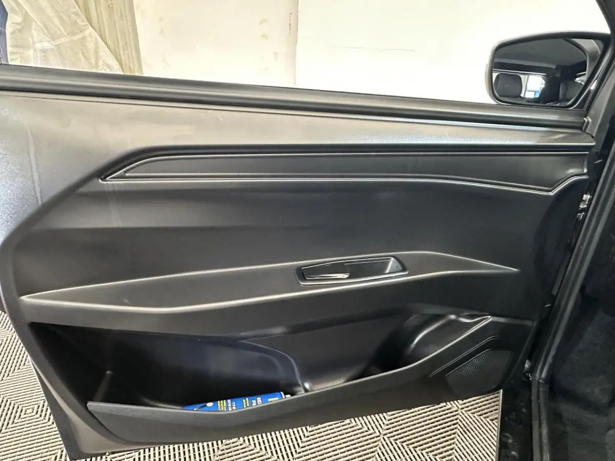 Intérieur montrant la porte côté conducteur noire avec poignée intégrée et rétroviseur extérieur caméra sur une Aixam Minauto E Access blanche 2025