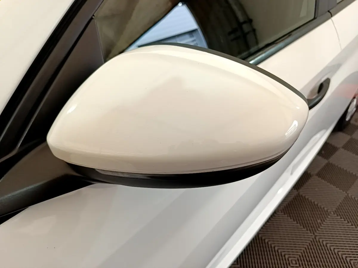 Rétroviseur côté conducteur blanc de la Peugeot 208 1.2 PT 75 S&S Premium vue rapprochée en intérieur.