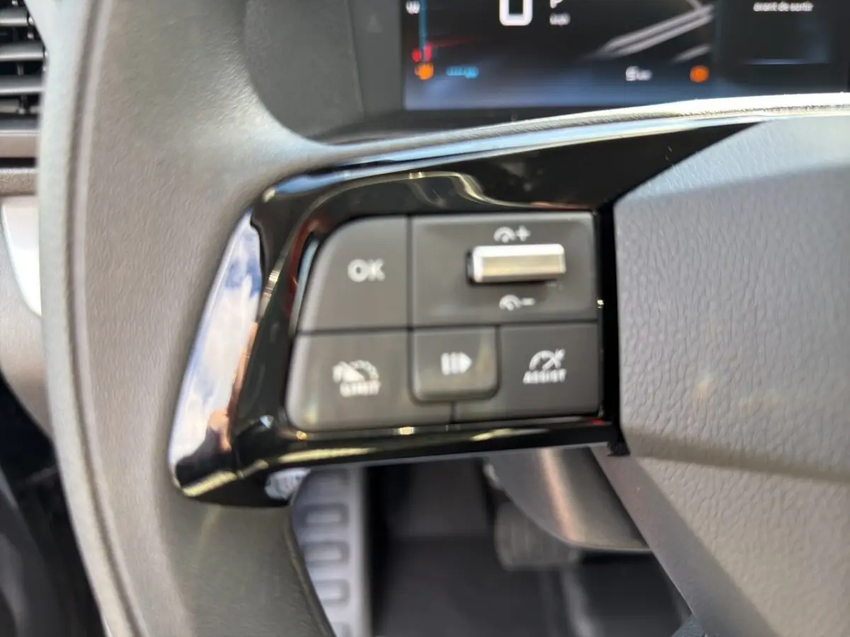 Gros plan sur les commandes multifonctions à gauche du volant du Citroën Jumpy gris foncé, intérieur cabine.
