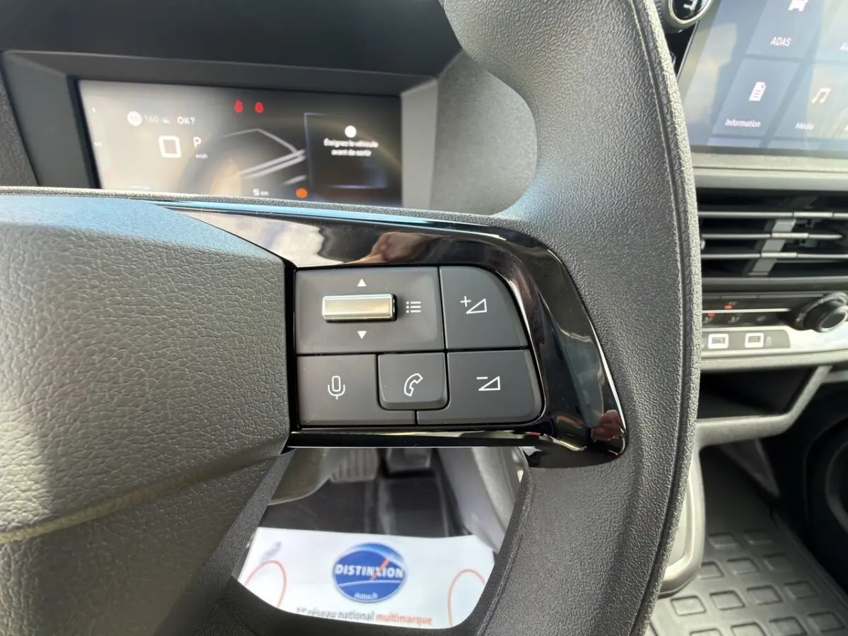 Gros plan sur le volant multifonctions noir du Citroën Jumpy gris foncé, avec commandes audio et téléphone visibles.