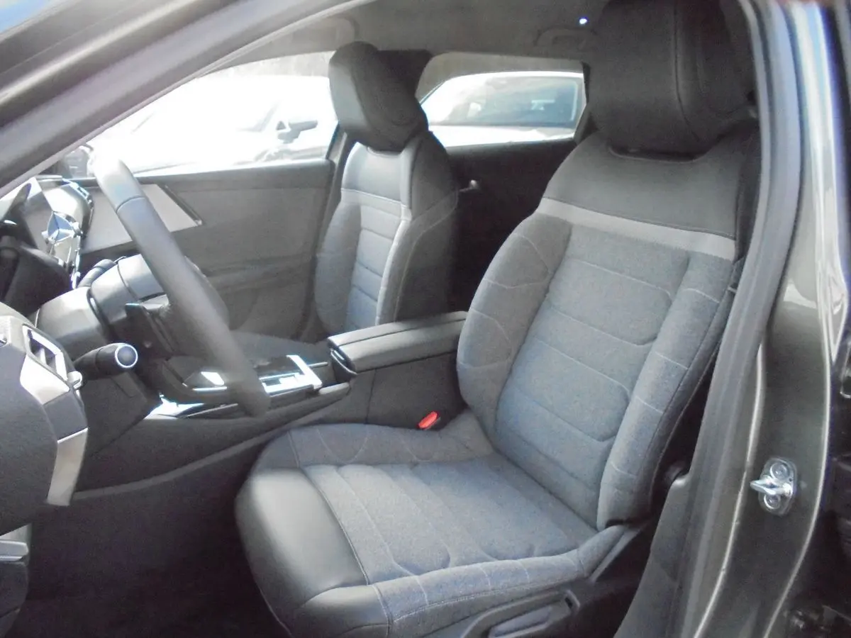 Intérieur avant droit de la Citroën C5 X 2022, sièges tissu gris avec cuir noir et console centrale moderne.