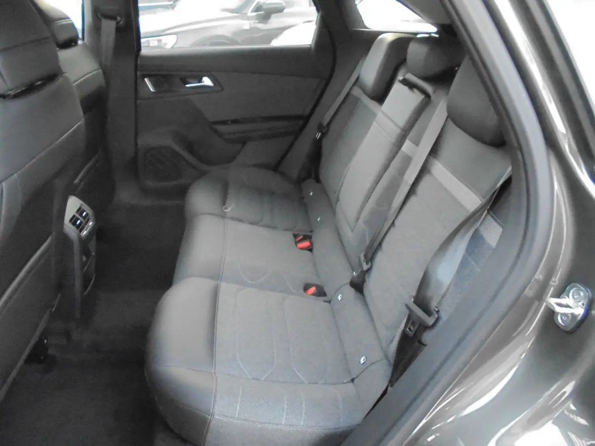 Vue intérieure sur les sièges arrière en tissu gris et cuir d'une Citroën C5 X gris platinium 2022, porte ouverte côté droit.