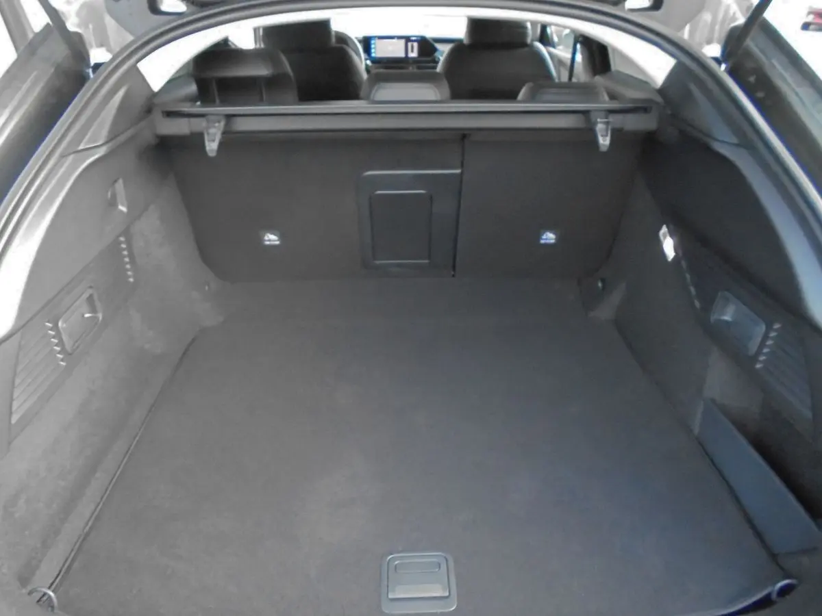 Coffre spacieux de la Citroën C5 X gris platinium, vue intérieure arrière avec banquette et tablette arrière visibles.