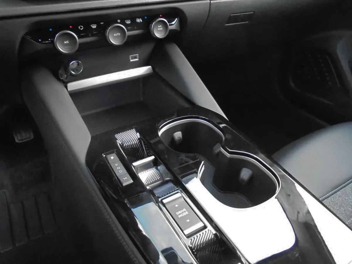 Vue rapprochée de la console centrale noire brillante avec sélecteur de boîte auto et commandes climatisation d'une Citroën C5 X 2022.