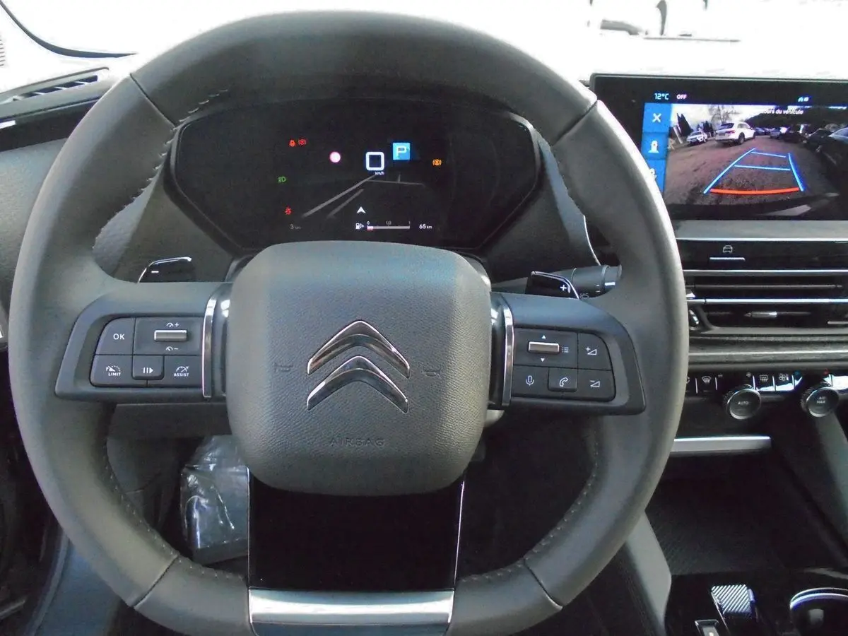 Volant cuir du Citroën C5 X 2022 avec commandes intégrées et écran affichant la caméra de recul en arrière-plan.