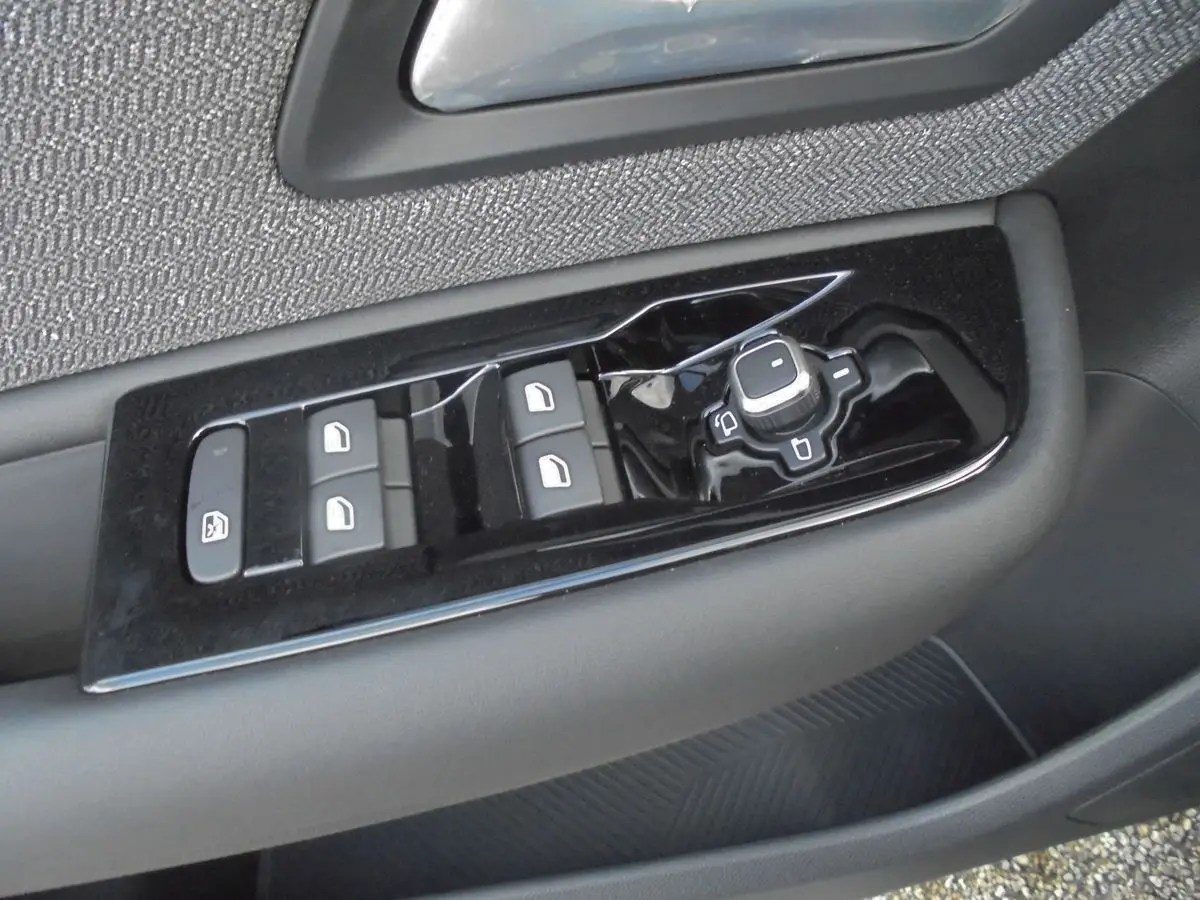 Gros plan sur les commandes de lève-vitres et rétroviseurs côté gauche d'une Citroën C5 X gris platinium 2022.