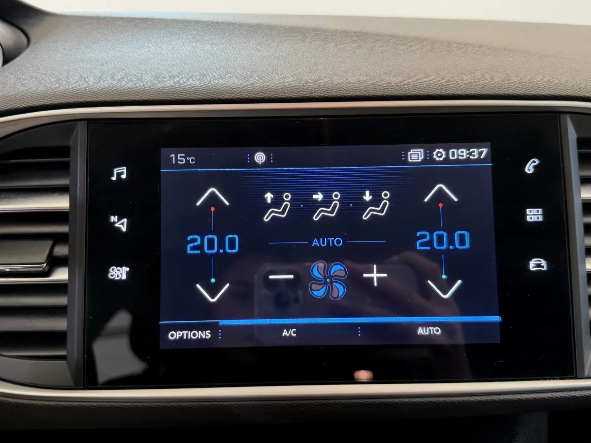 Écran tactile central de la Peugeot 308 blanc affichant la climatisation bi-zone réglée à 20°C en mode automatique