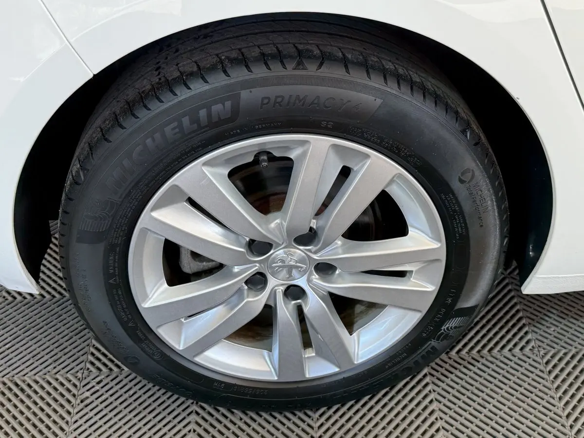 Gros plan sur la roue avant droite blanche d'une Peugeot 308 2021 avec jante alliage et pneu Michelin Primacy 4.