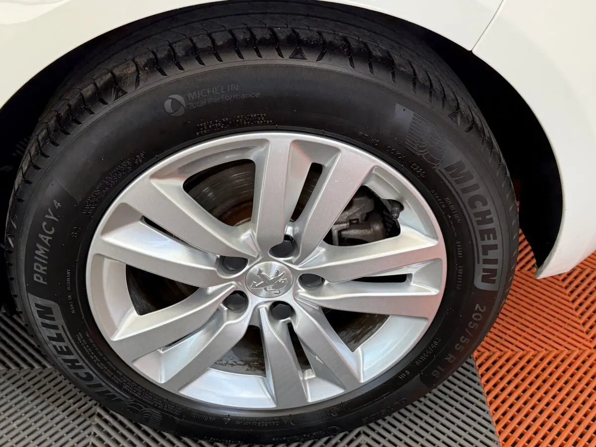 Gros plan sur la roue avant droite de la Peugeot 308 blanche, avec jante alliage et pneu Michelin Primacy 4 visible.
