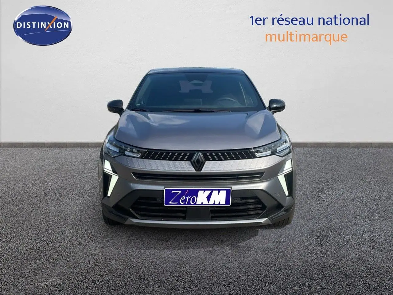 Vue frontale d'un Renault Captur E-Tech hybride gris Cassiopée avec toit noir, éclairage LED distinctif allumé.