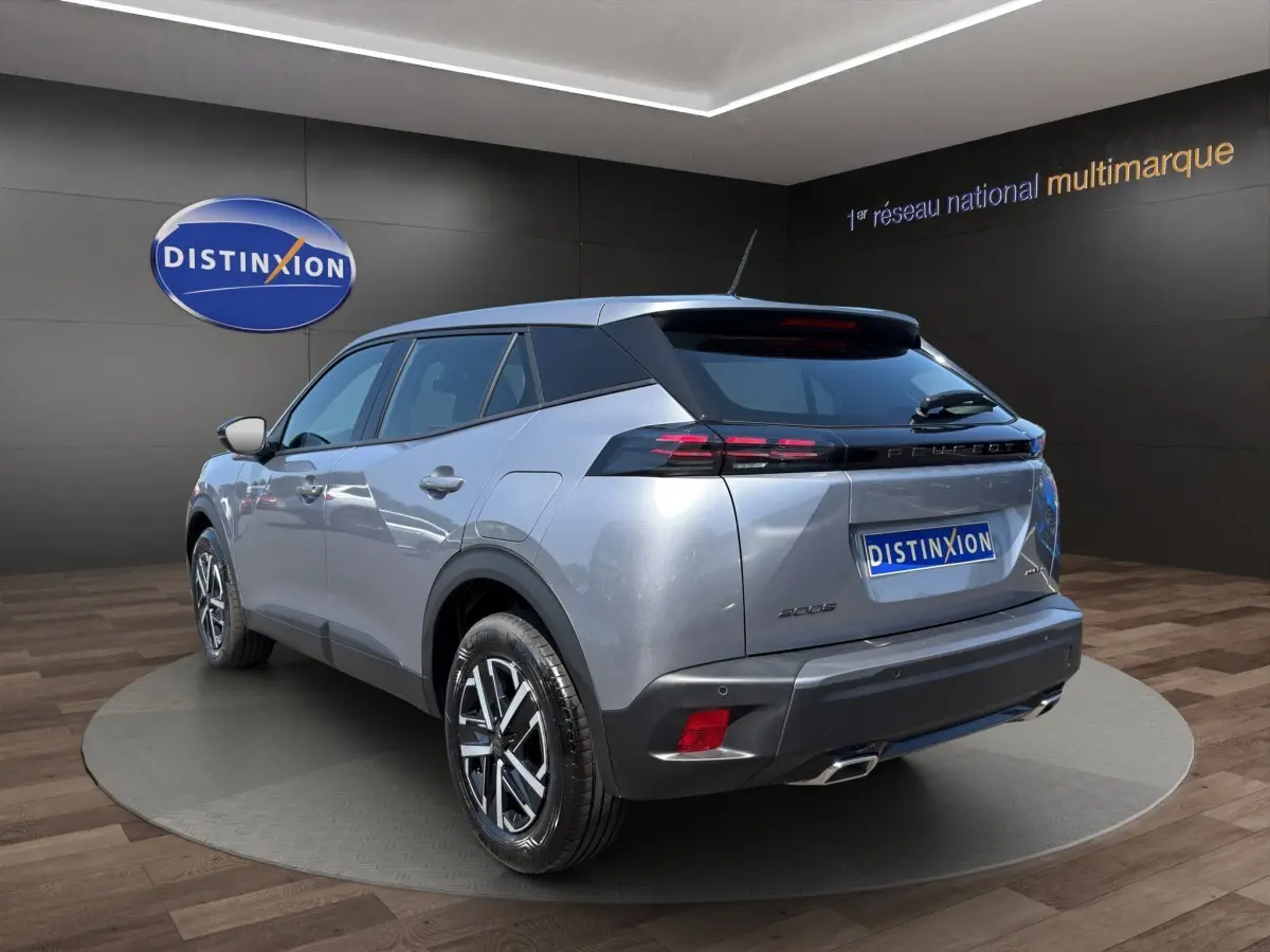 Peugeot 2008 Hybrid 145 e-DCS6 STYLE gris clair, vue 3/4 arrière droit, feux LED et jantes alliage visibles.