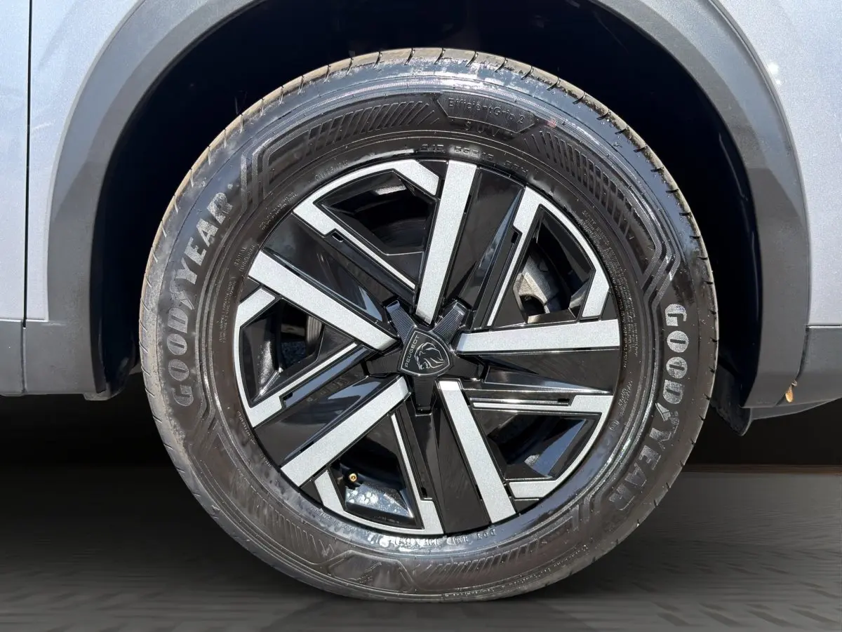 Gros plan sur la roue avant droite gris clair du Peugeot 2008 Hybrid 145 e-DCS6 STYLE avec jante noire et argentée.
