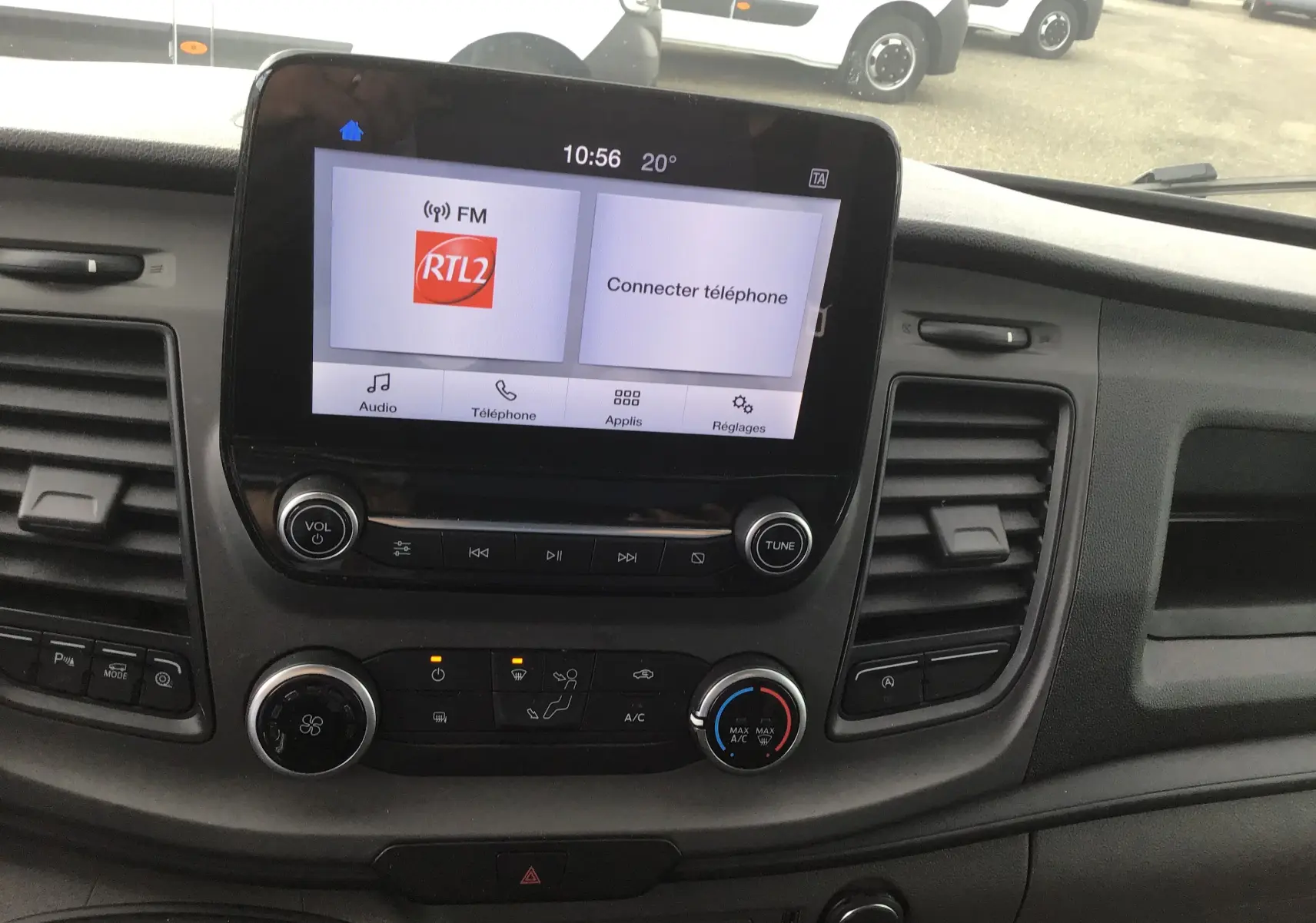 Vue intérieure du tableau de bord du Ford Transit Fourgon 2020 avec écran tactile affichant la radio RTL2 et commandes de climatisation.