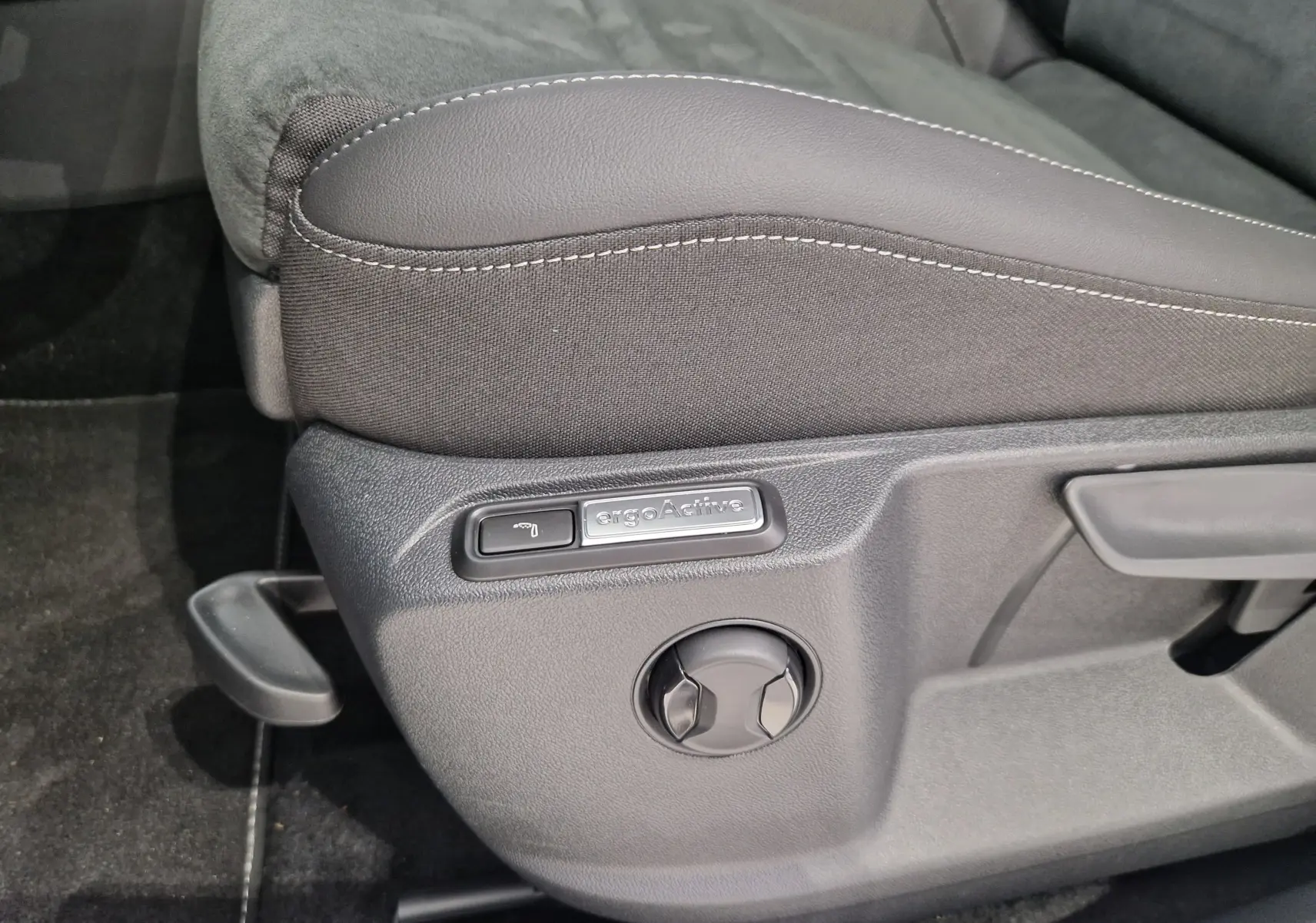 Détail du réglage de siège ergoActive en tissu noir sur Volkswagen T-Roc gris Indium Metal, côté gauche.