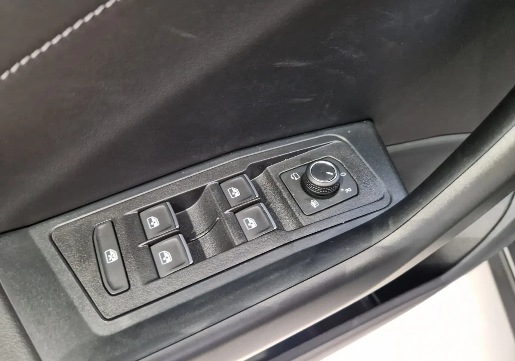 Commande des vitres électriques et réglage des rétroviseurs sur la porte côté conducteur du Volkswagen T-Roc gris indium.