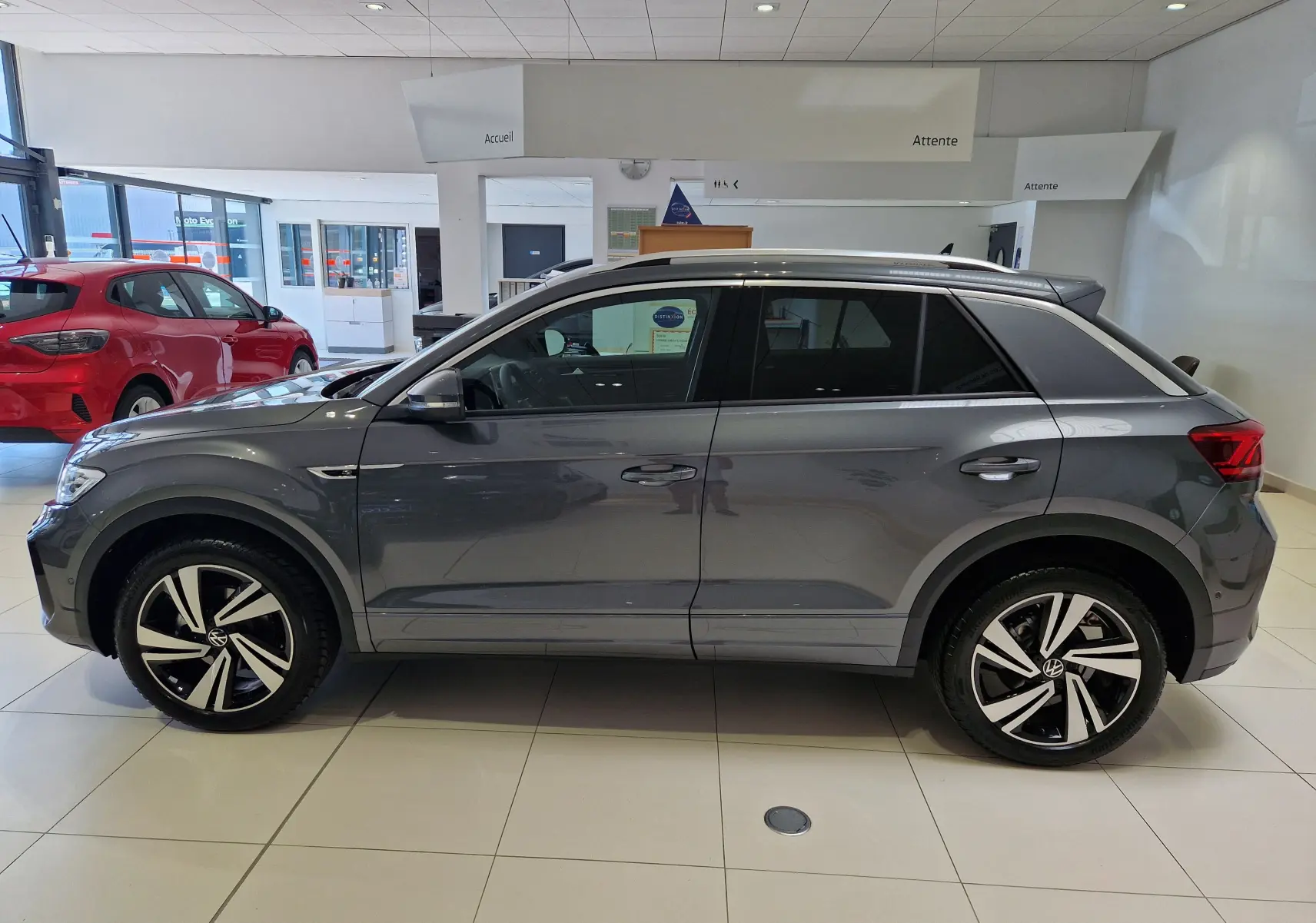 Profil côté gauche d'un Volkswagen T-Roc gris Indium Metal 2025 en finition R-Line Edition avec jantes alliage bicolores.