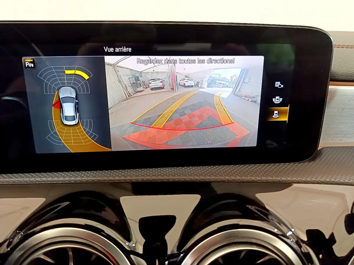 Écran tactile intérieur de la Mercedes CLA 200 d AMG Line noir montrant la caméra de recul avec aides au stationnement.
