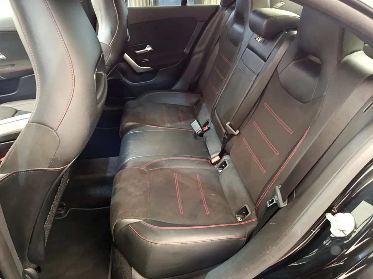 Vue intérieure côté droit des sièges arrière noirs avec surpiqûres rouges de la Mercedes CLA 200 d AMG Line 2021