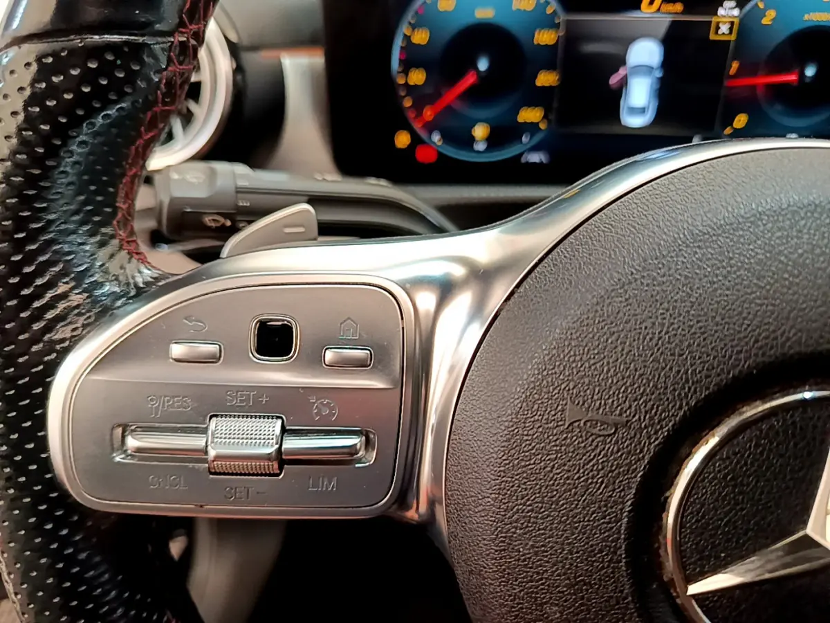 Gros plan sur le volant cuir noir de la Mercedes CLA 200 d AMG Line 2021 avec commandes multifonctions et tableau de bord numérique.