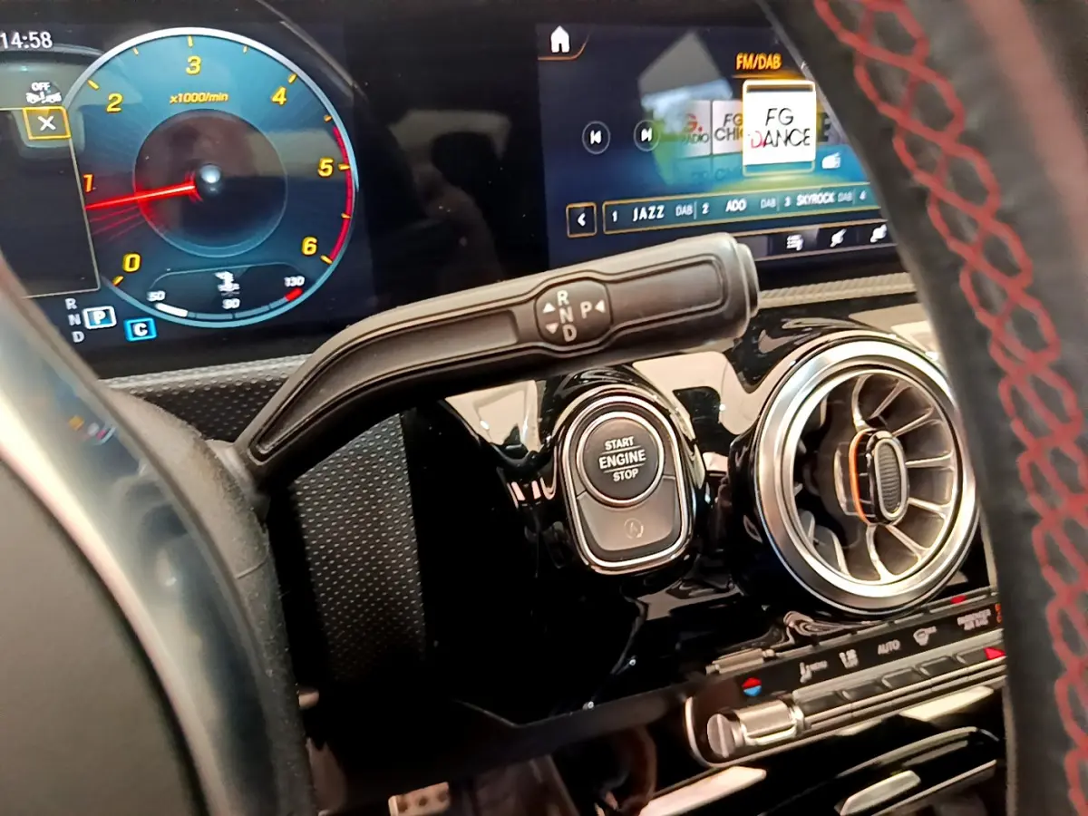 Détail intérieur du tableau de bord noir du Mercedes CLA 200 d AMG Line avec bouton start et levier de vitesses.