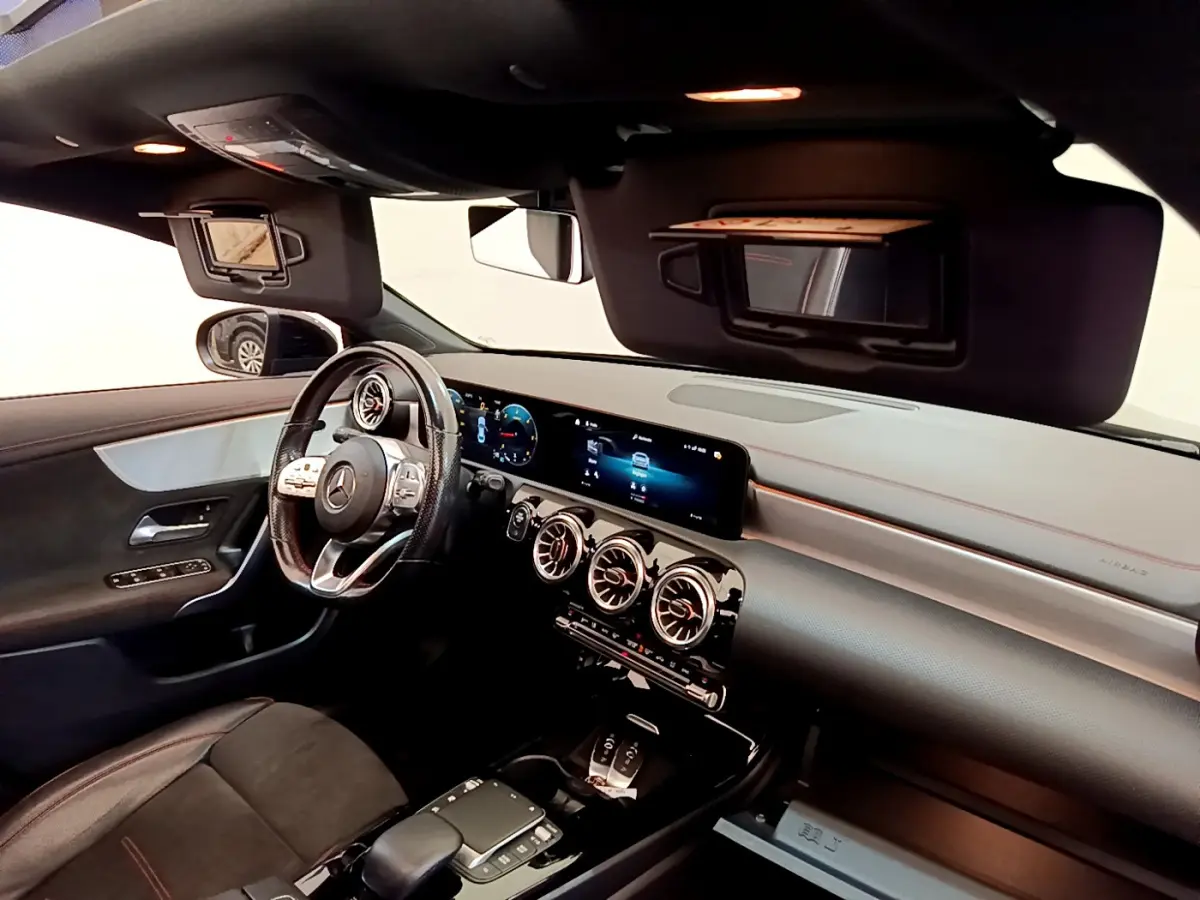 Intérieur noir de la Mercedes CLA 200 d AMG Line 2021 vu côté conducteur, tableau de bord digital et volant cuir.