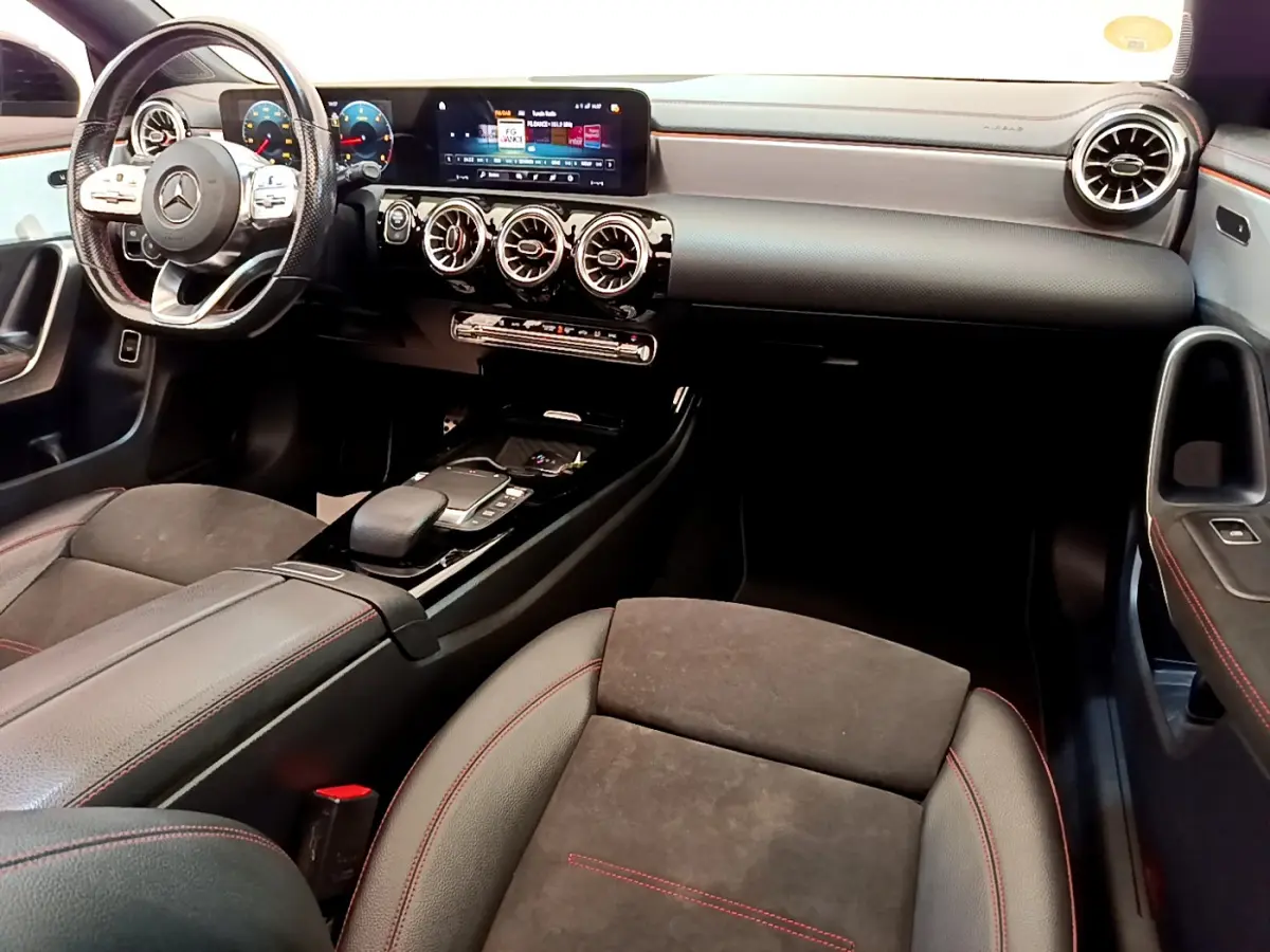 Intérieur noir du Mercedes CLA 200 d AMG Line 2021, vue de l'habitacle côté passager avec tableau de bord et volant multifonctions.