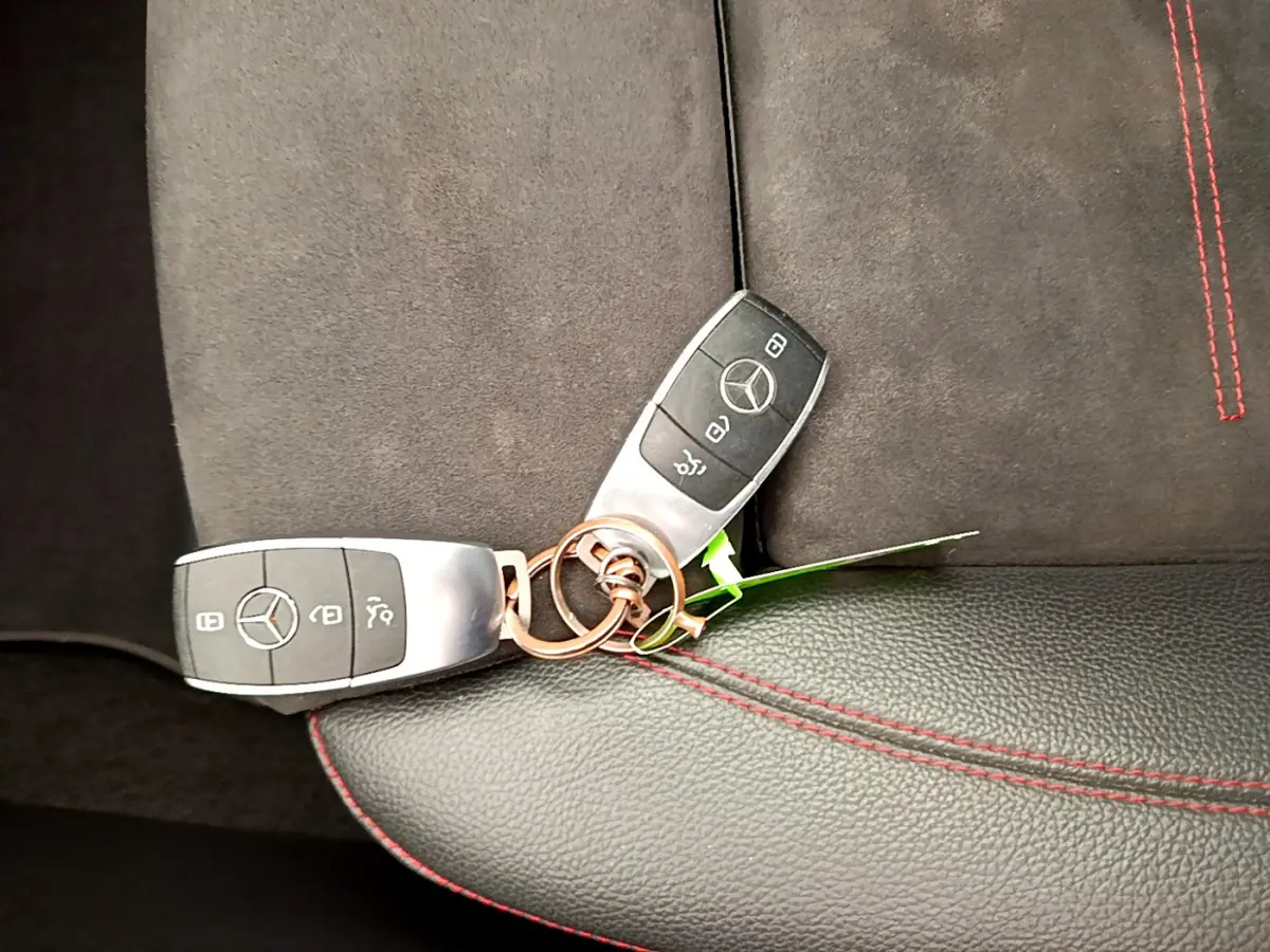 Clé Mercedes posée sur siège cuir noir et alcantara avec surpiqûres rouges, intérieur CLA 200 d AMG Line 2021.