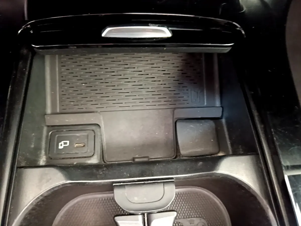 Vue rapprochée de la console centrale noire de la Mercedes CLA 200 d AMG Line avec chargeur sans fil et port USB-C.
