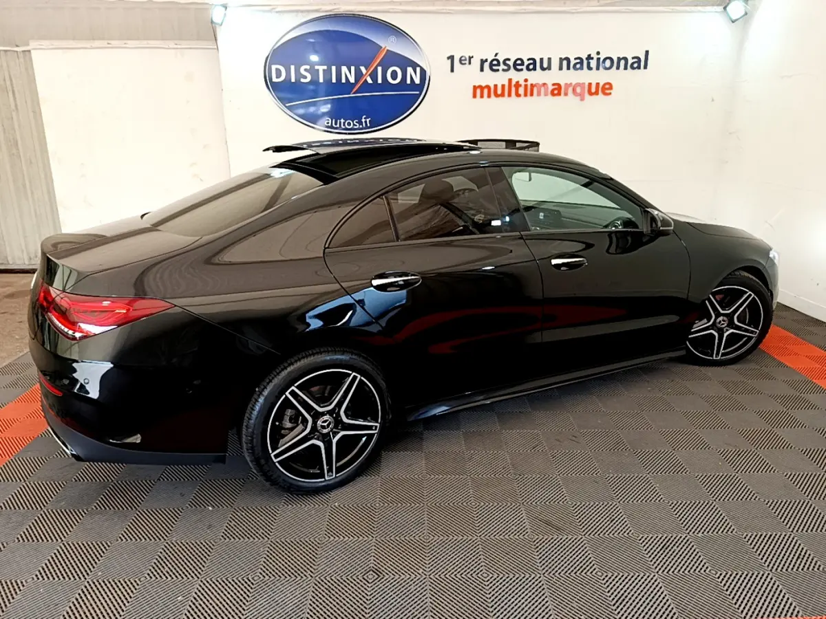 Vue 3/4 arrière côté gauche d'une Mercedes CLA 200 d AMG Line noire avec jantes AMG et toit ouvrant panoramique.
