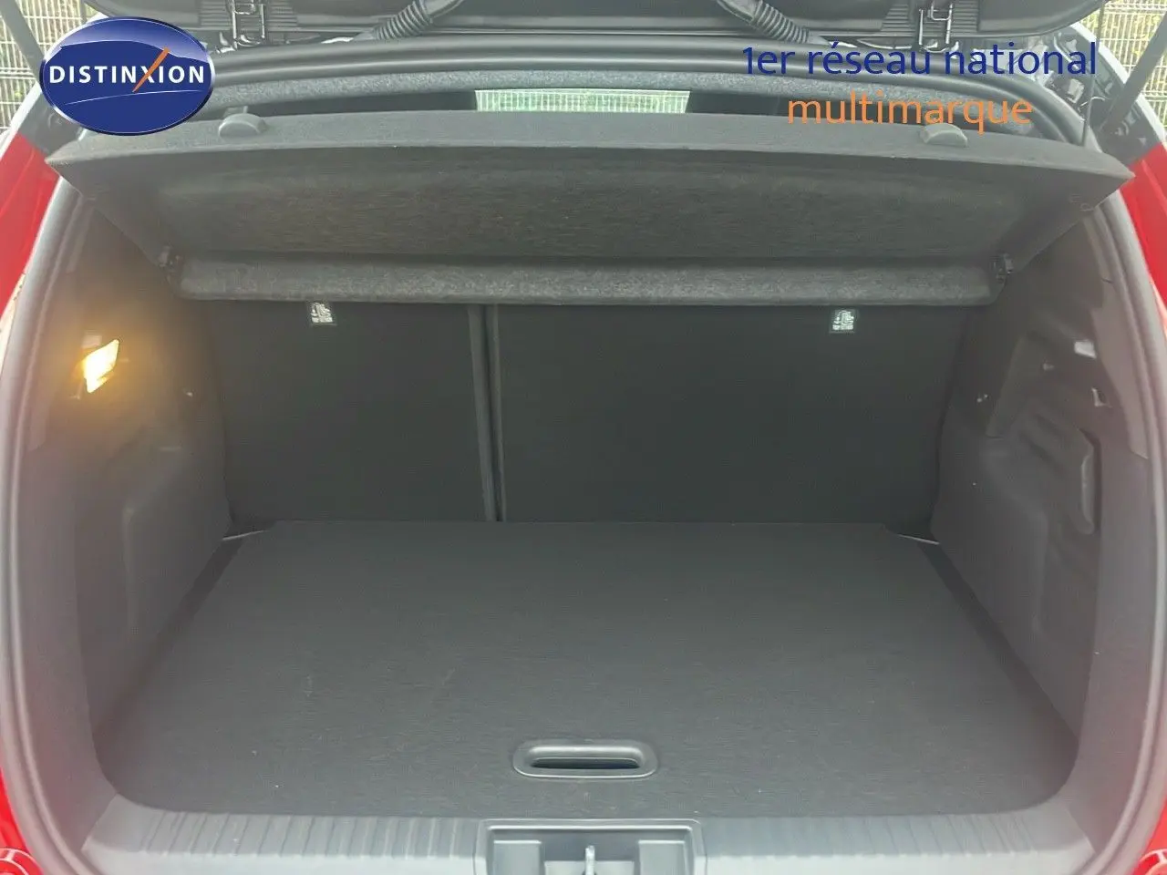 Coffre ouvert du Renault Captur E-Tech hybride rouge passion, vue arrière montrant l’espace de chargement vide.