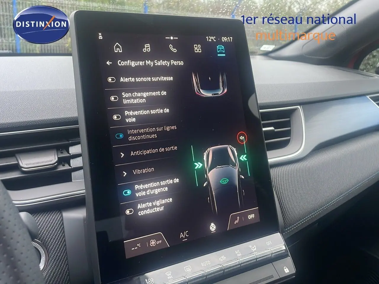 Vue rapprochée de l’écran tactile central du Renault Captur E-Tech rouge, affichant les aides à la conduite.