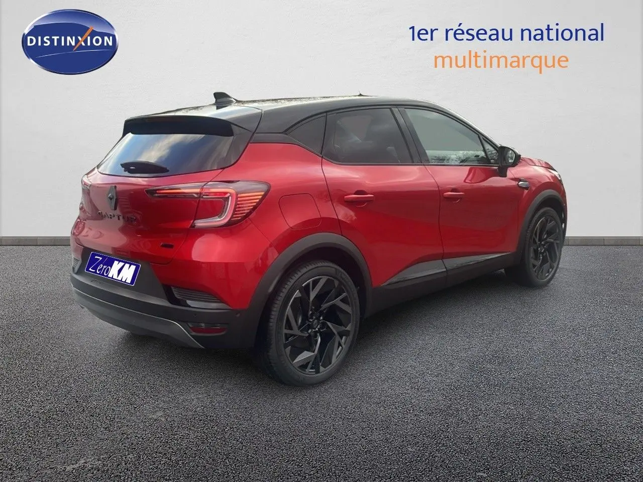 Vue 3/4 arrière droite d’un Renault Captur E-Tech hybride rouge passion avec toit noir et jantes noires.