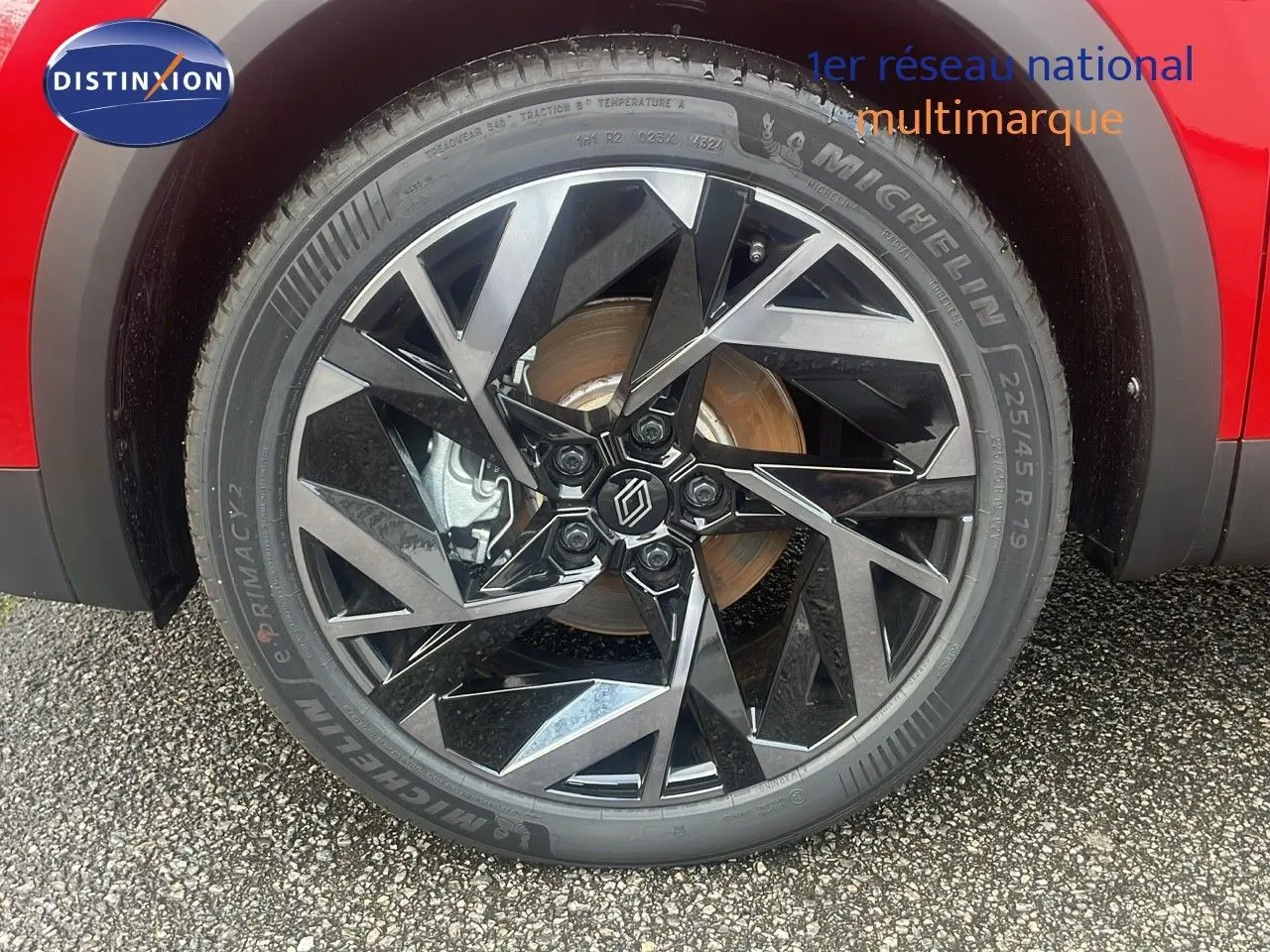 Gros plan sur la jante avant droite diamantée noire et argent du Renault Captur E-Tech rouge passion toit noir.