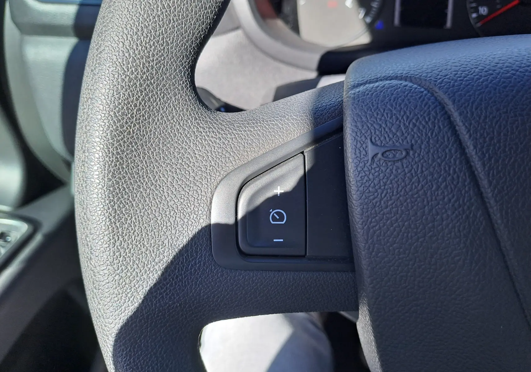 Gros plan sur le volant noir du Nissan Interstar Chassis Cabine 2024, montrant les commandes de réglage d’éclairage.
