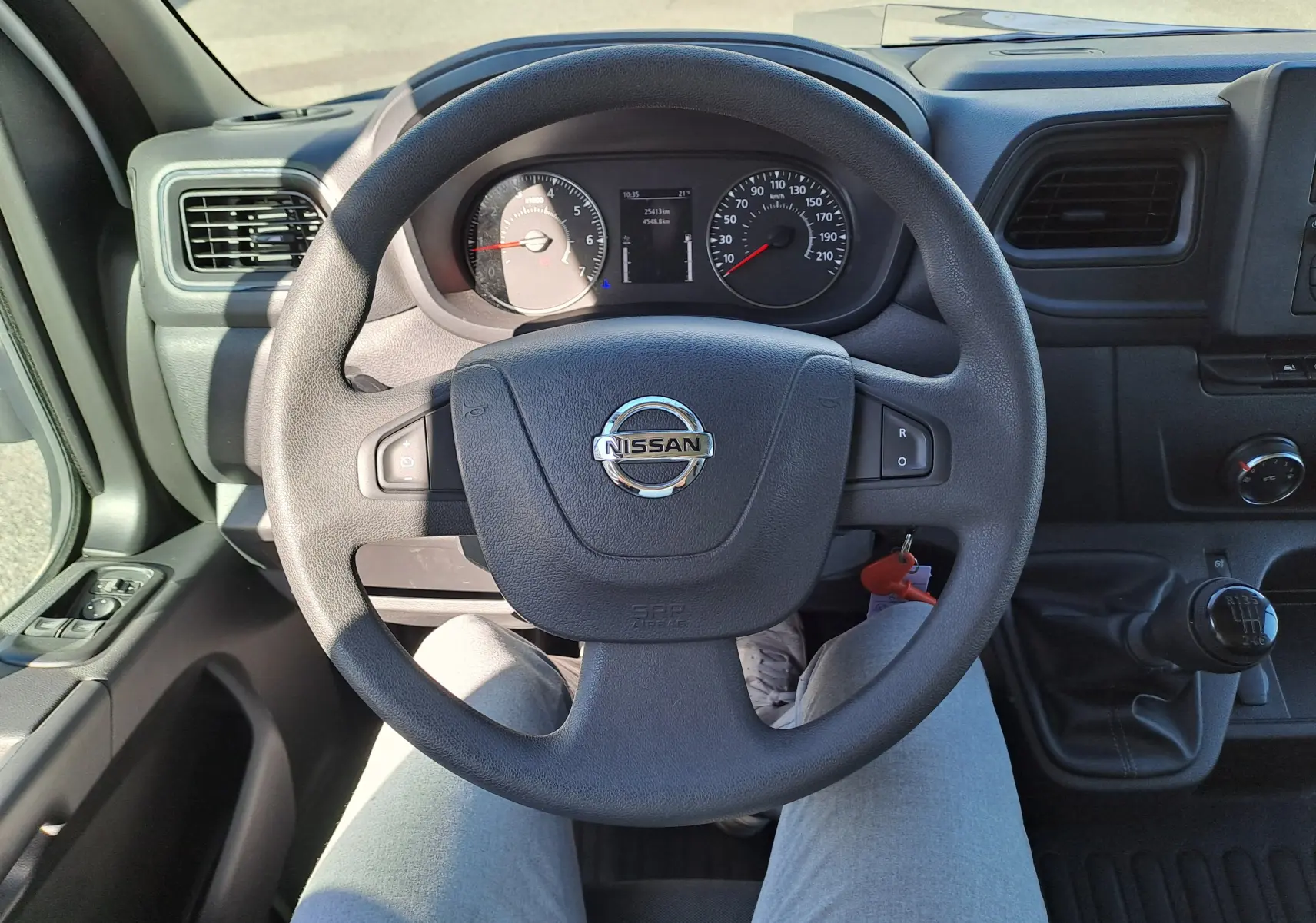 Vue intérieure centrée sur le volant Nissan d'un Interstar Châssis Cabine blanc 2024 avec boîte manuelle et tableau de bord visible.