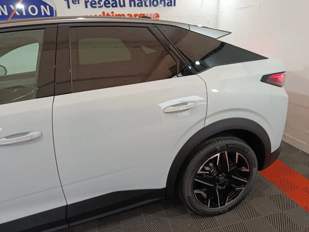 Vue latérale droite du Peugeot 3008 blanc hybride 2025, soulignant la roue arrière noire et les vitres teintées.