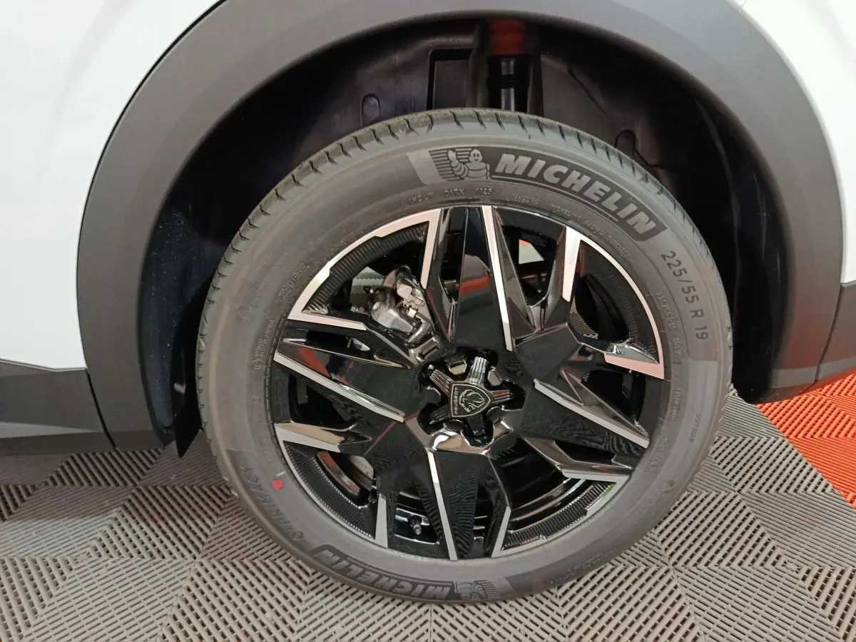 Gros plan sur la roue avant droite du Peugeot 3008 blanc, jante noire brillante au design moderne avec pneu Michelin.