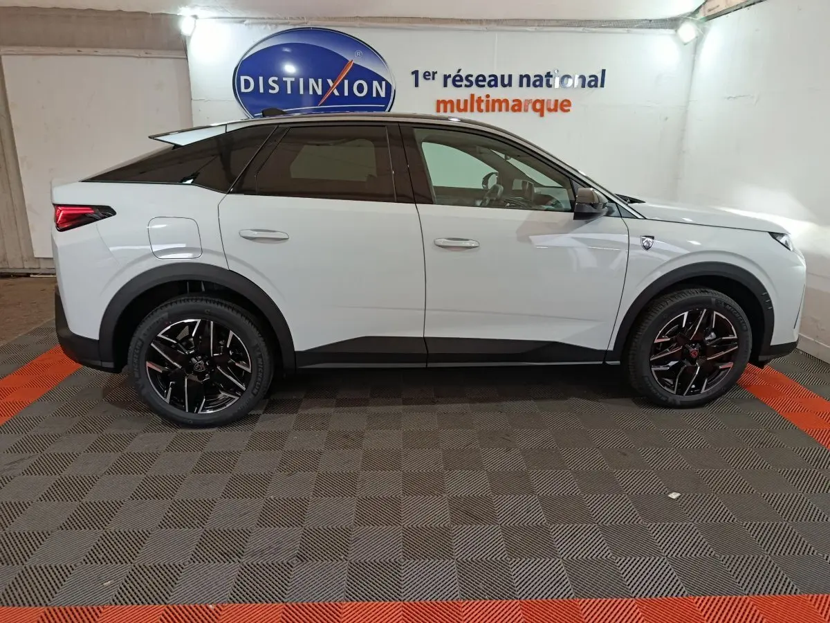 Profil côté gauche du Peugeot 3008 blanc 2025 avec toit noir et jantes noires en intérieur showroom