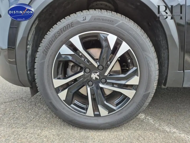 Gros plan sur la jante alu noire et argentée du côté avant droit d’un Peugeot 2008 Noir Perla Nera.