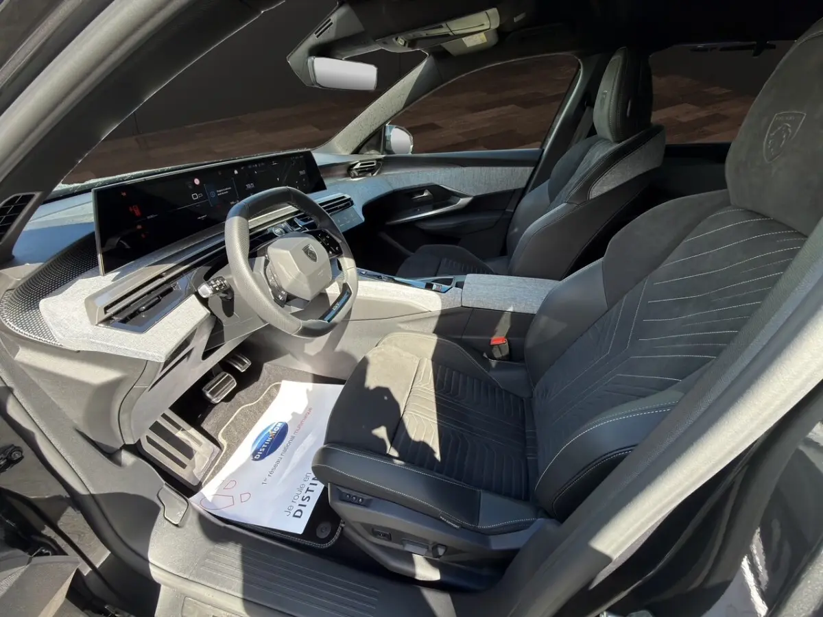 Vue intérieure côté conducteur du Peugeot 5008 gris foncé, avec sièges Alcantara et tableau de bord numérique panoramique.