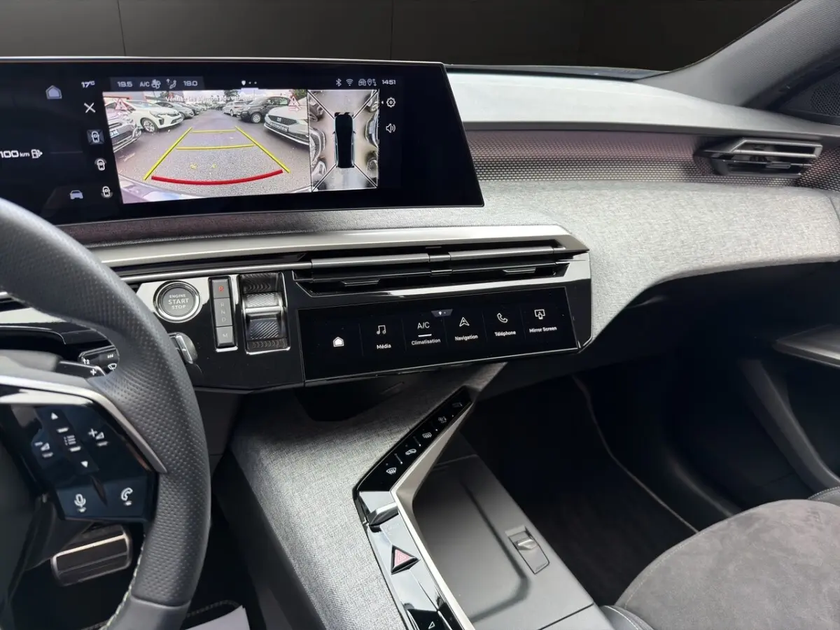 Vue intérieure du tableau de bord gris clair du Peugeot 5008 2025 avec écran tactile multifonctions et volant partiel visible.