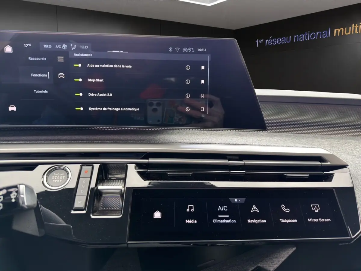 Vue intérieure du tableau de bord du Peugeot 5008 gris foncé, avec écran tactile multifonctions et commandes modernes.