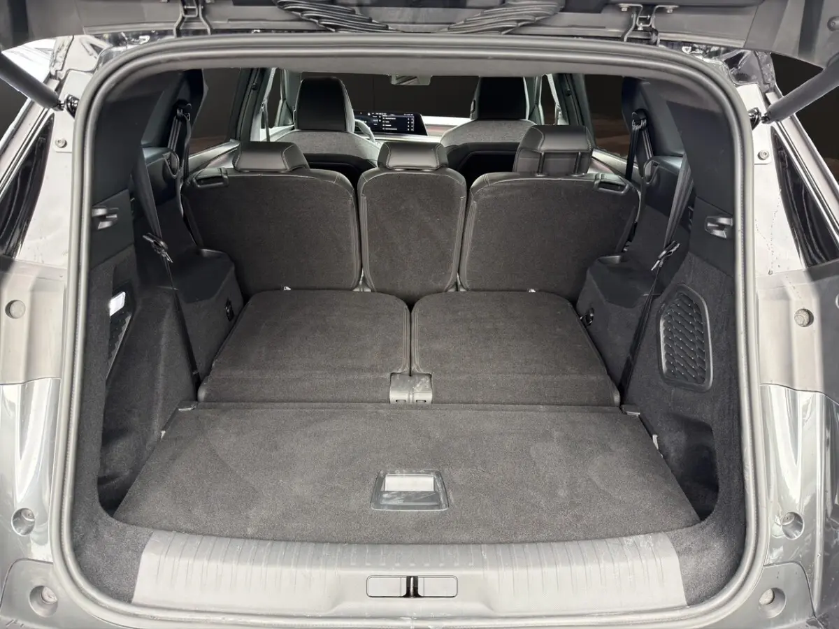 Coffre ouvert du Peugeot 5008 gris foncé, vue arrière montrant la 3ème rangée de sièges rabattue et l'espace de chargement.