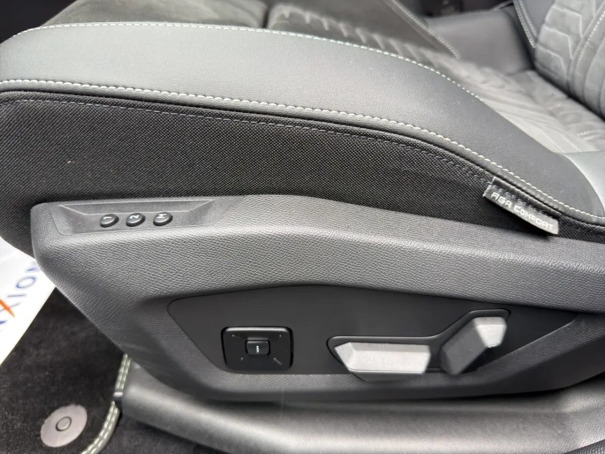 Gros plan sur les commandes de réglage électrique du siège avant en cuir noir et tissu gris du Peugeot 5008 2025.