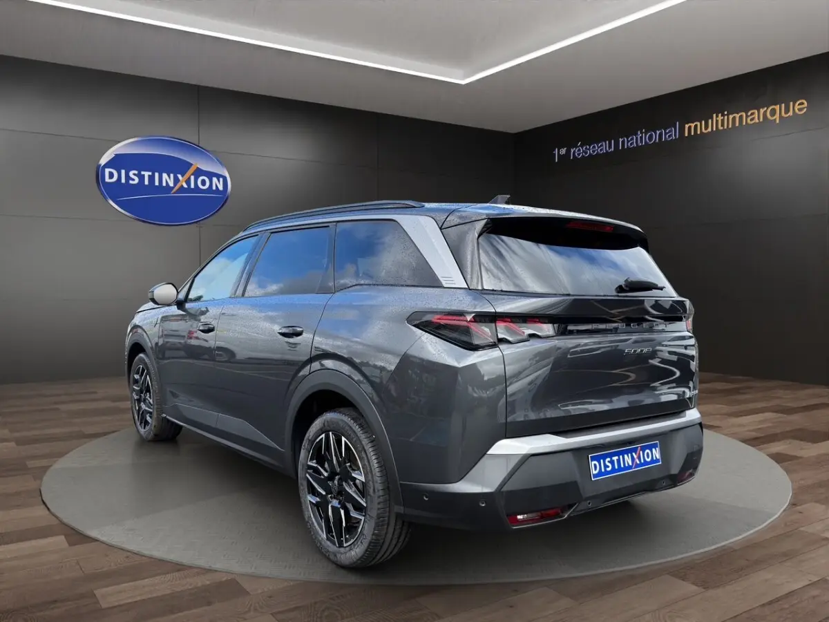 Peugeot 5008 gris foncé en 3/4 arrière droit, avec jantes noires et toit noir brillant, en showroom.