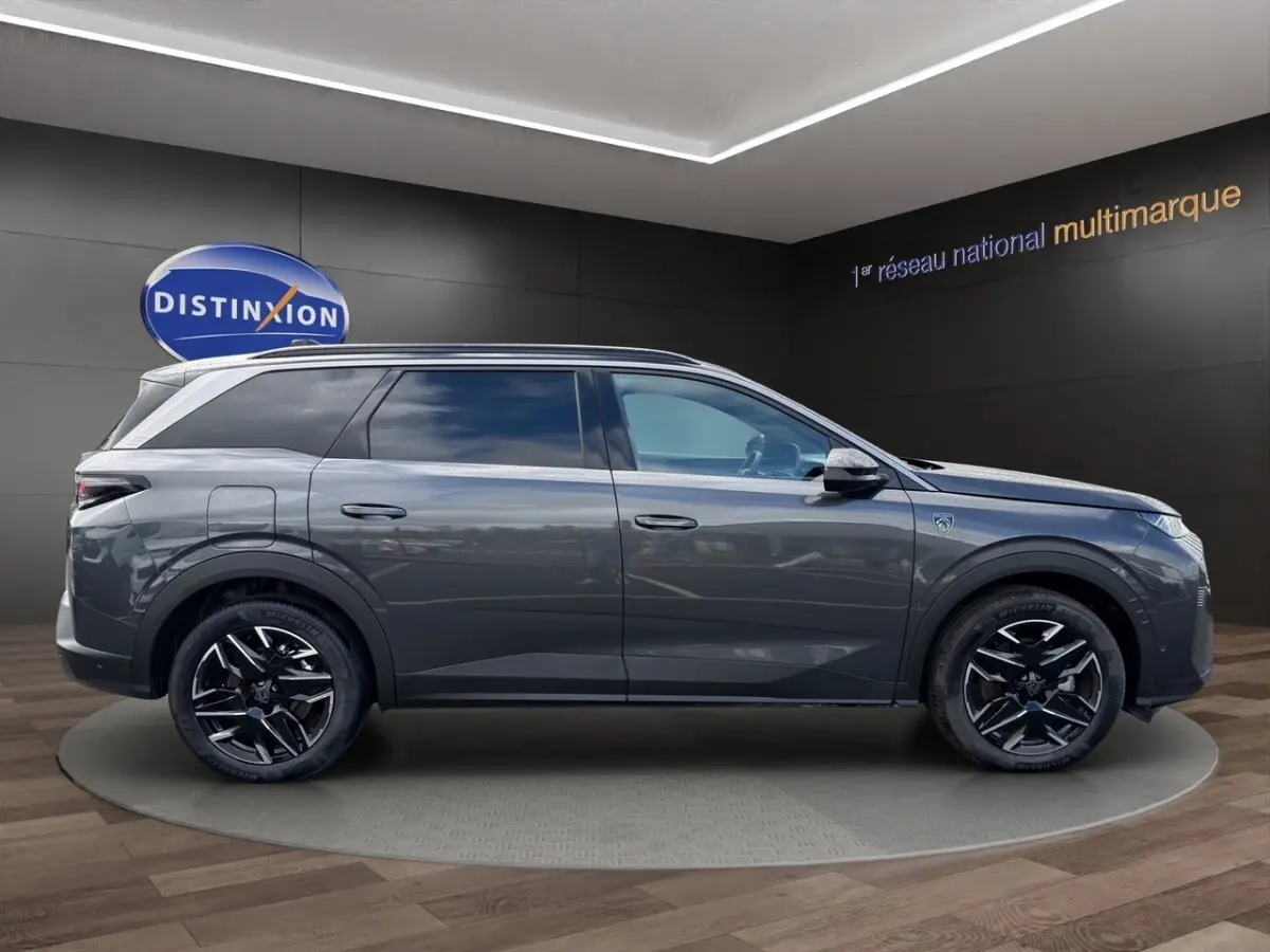Peugeot 5008 gris foncé vue de profil côté gauche, avec jantes noires et toit ouvrant panoramique.