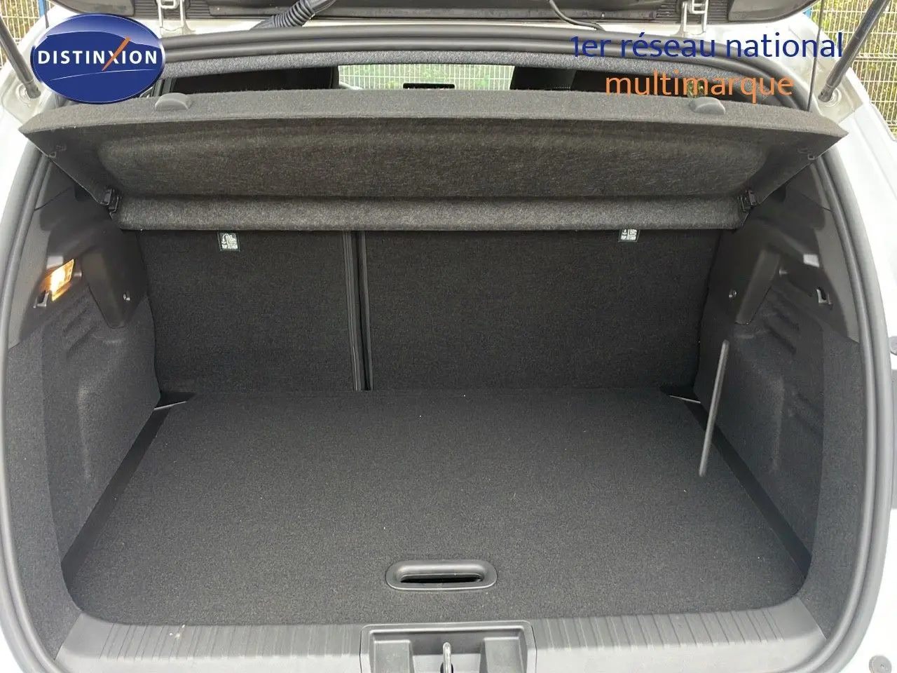 Coffre ouvert vu de l'arrière du Renault Captur blanc nacré avec toit beige, montrant un espace de chargement propre et spacieux.